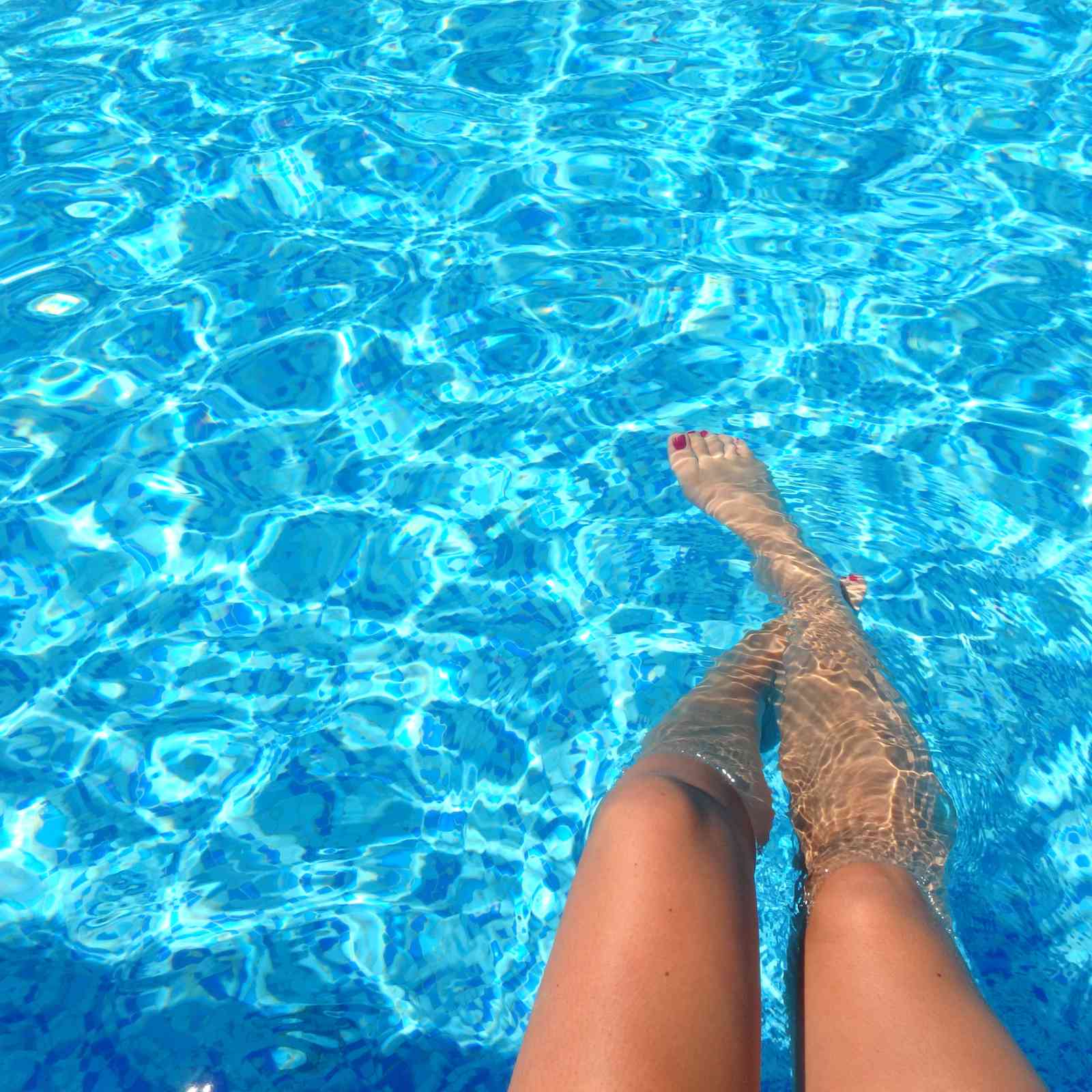 Les pieds dans l'eau d'une piscine